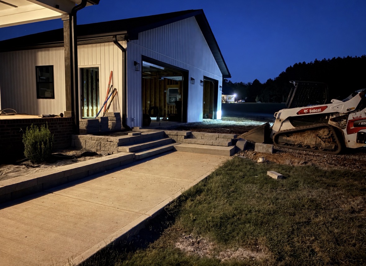 New block wall and steps beside a concrete walkway at dusk at a residential property